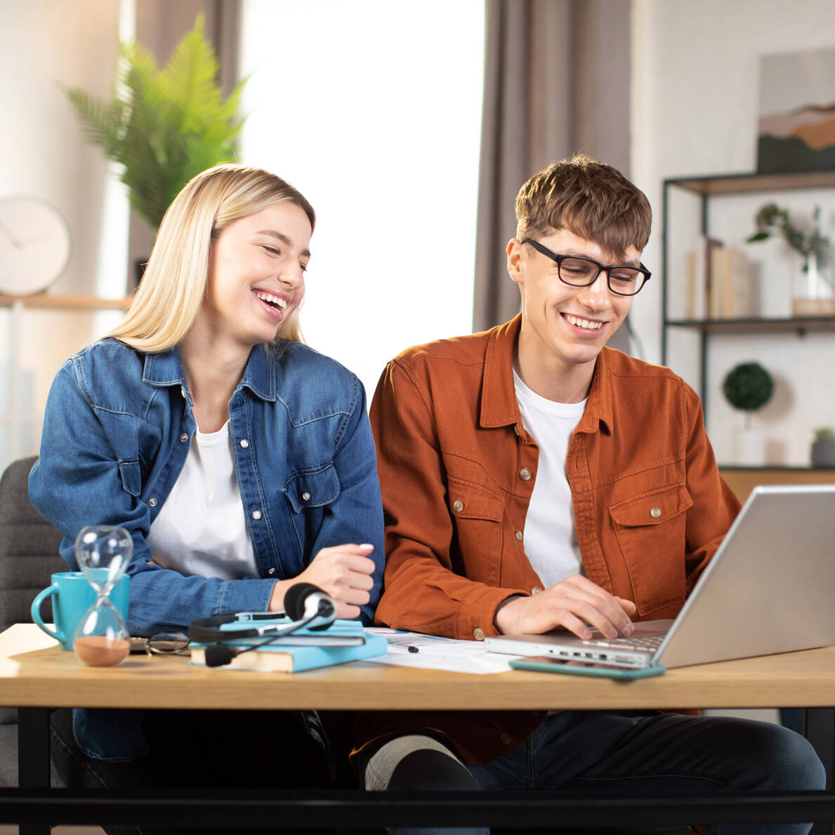 Junger Mann und junge Frau suchen am Laptop nach dem richtigen Studium